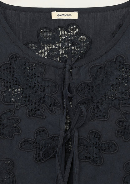 A sleeveless tie front top in black with tonal lacework detailing and peplum hem.