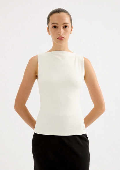 A woman wearing a solid white sleeveless tank top with high round neckline.