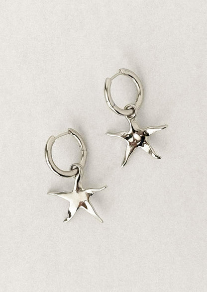 A pair of silver star earrings on hoop.