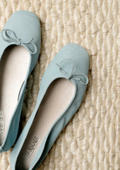A pair of suede ballet flats in light blue.